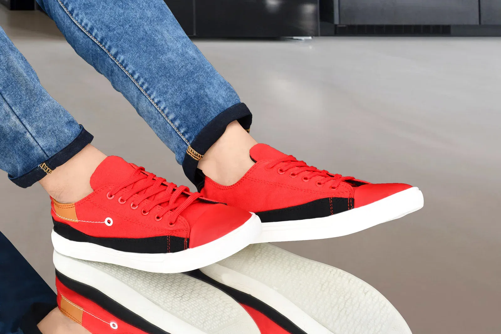 Cheap Canvas Shoes for Men – 4 Stylish Two-Tone Casual Shoes for Comfort and Versatility 8 Men's red and black canvas sneakers with white soles, paired with blue denim jeans, showcasing a trendy fashion shoe style.